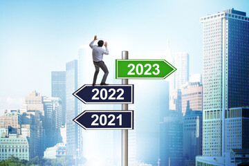 Businessman on signpost from 2022 to 2023