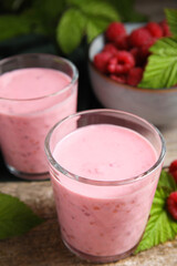 Tasty raspberry smoothie and fresh berries on wooden table, closeup