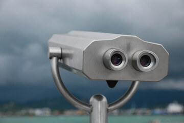 Metal tower viewer installed near sea, closeup. Mounted binoculars