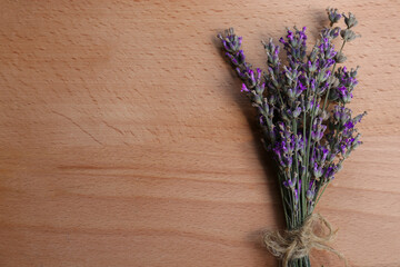 Bouquet of beautiful lavender flowers on wooden table, top view. Space for text