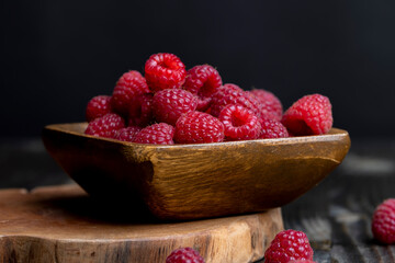 The harvest of red ripe raspberries is on the board