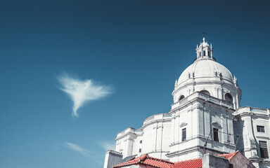 Obraz premium View of The Church of Santa Engracia or another name National Pantheon on a very sunny day, with a blue sky and a single cloud in the shape of an angel next to the dome and walls of the church