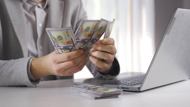 Man counts dollars and looks. Finance and investments.
Counting money splitting money. Financial and investments.
