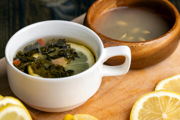 Green tea in a white cup during its brewing