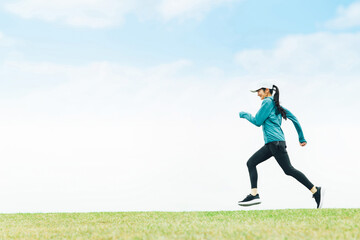 公園でジョギングしてダイエットするランナーのアジア人女性
