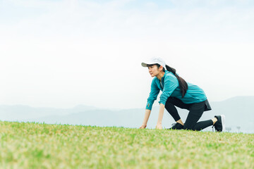 Naklejka na ściany i meble 公園で短距離走・全速力で走る練習をするスポーツウェアを着た陸上選手のアジア人女性 