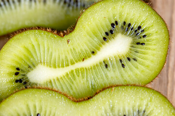 Kiwi slices cut with a knife on a board