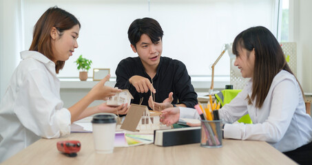 Team of architects working on construction plans, discussing over building project in office.
