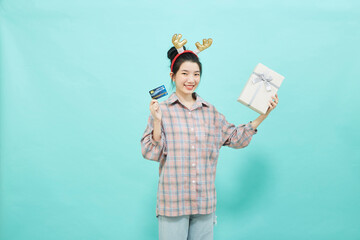 Cheerful cute woman holding a gift box with a credit card
