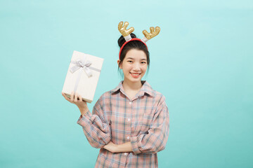 Cheerful cute woman holding a gift box with a credit card