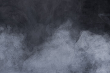 Dense Fluffy Puffs of White Smoke and Fog on black Background, Abstract Smoke Clouds, Movement Blurred out of focus. Smoking blows from machine dry ice fly fluttering in Air, effect texture