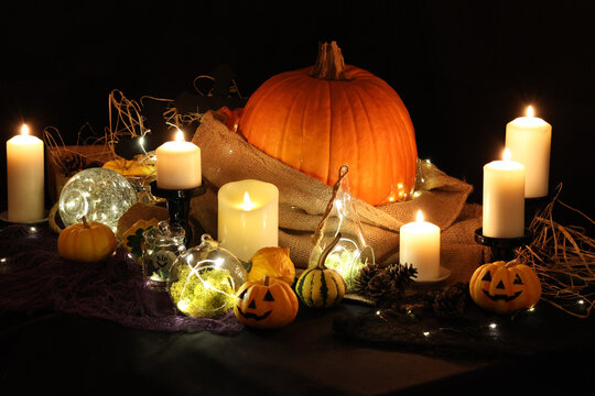 ハロウィンの飾り付け　キャンドルの光に灯されたお化けカボチャやジャックオーランタン　ハロウィーンのイメージ