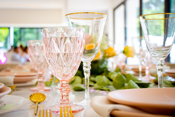 Copas de cristal rosa y transparente con fondo decorado en fiesta