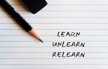 Pencil eraser on paper background with handwritten text Learn Unlearn Relearn - concept of knowing...
