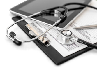 Stethoscope, tablet and medical report on white background