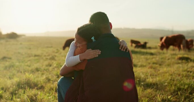 Love, family and hug with a father and girl in a field outdoor on a cow farm. Cattle farmer and little kid in the farming, agricultural and dairy industry on a meadow or pasture outdoors in sunset