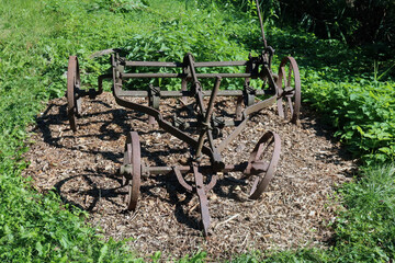 Old broken rusty plow in the backyard of a village house