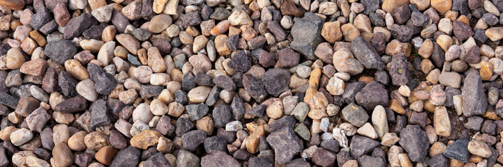 Different colored beach pebbles stones as background. Panorama