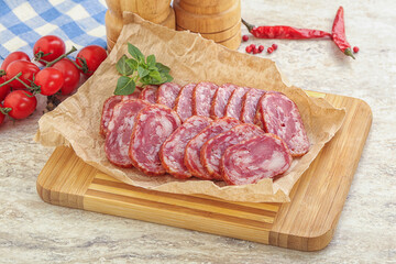 Sliced salami sausages over board