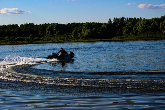 Man Floating Down The River In A Motorboat