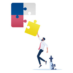 Businessman connecting the last piece of jigsaw puzzle to complete the mission