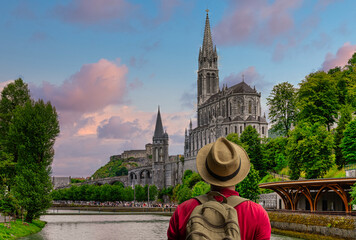 Man with hat looking at the Sanctuary of Our Lady of Lourdes 
