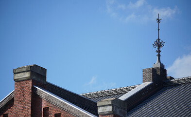 Lightning rod on roof of building on a clear blue sky day - obrazy, fototapety, plakaty