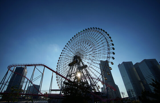 Urban Ferris wheel on a clear blue sky day
