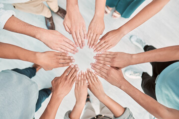 Hands, collaboration and motivation with a business team standing in a huddle or circle from above. Teamwork, goal and unity with a man and woman employee group together in the office for support