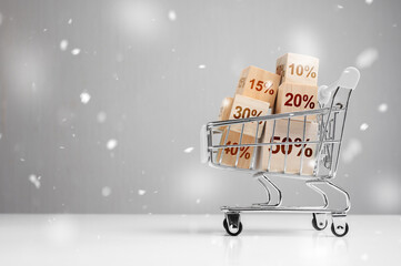 Winter Sale. New year or Christmas holiday shopping concept. Shopping cart and red percentage sign...