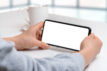 mockup cellphone horizontal position. Mockup image of woman holding black mobile phone with blank...