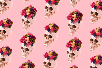 Modern idea made of skull with colorful dried flowers on pastel pink background. Minimal Halloween...