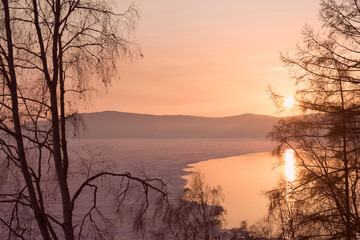 Beautiful sunset on frozen lake Baikal. Winter landscape.