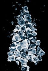 An idea concept of a Christmas card. A Christmas tree shape, made of natural ice cubes on a black...