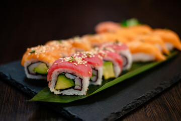 Thunfisch und Lachs und Maki Rolls auf einem Blatt