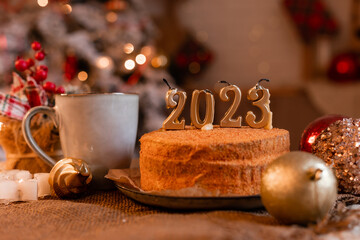 homemade honey cake in the kitchen with candles 2023. Cozy New Year at home. Merry Christmas. High quality photo
