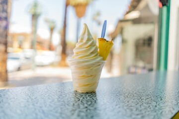 pineapple dole whip frozen yogurt ice-cream with a pineapple wedge on a countertop - obrazy, fototapety, plakaty