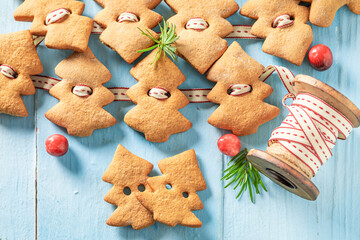 Aromatic gingerbread cookies chain as Christmas ornaments.