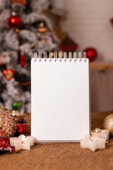 Naklejka na ściany i meble notebook with empty pages on a wooden table in the kitchen against the background of a Christmas tree. New Year's recipes. space for text. High quality photo