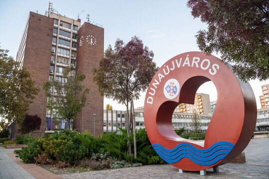 Dunaujvaros, Hungary &ndash; October 18, 2022. Varoshaza city hall and Love Dunaujvaros sign in Dunaujvaros, Hungary. View with surrounding buildings and vegetation. 