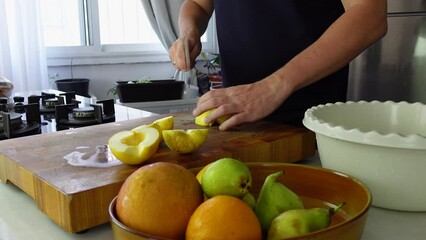 Chef cook cutting fresh apples for fruit salad on wooden cut board