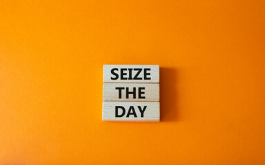 Seize the day symbol. Wooden blocks with words Seize the day. Beautiful orange background. Business and Seize the day concept. Copy space.