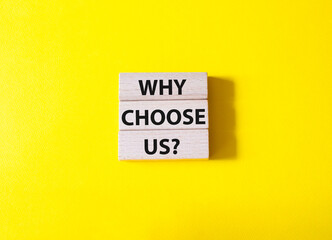 Why choose us symbol. Concept words Why choose us on wooden blocks. Beautiful yellow background. Business and Why choose us concept. Copy space.