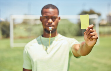 Soccer, referee and yellow card with a black man giving a caution to a player during a game...