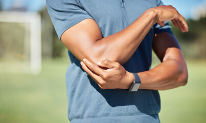 Sports man with elbow pain on arm, injury in outdoor soccer field. Hand massage bone, person with...