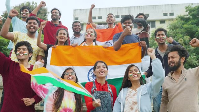 Audience at stadium shouting India india by holding lags with tricolor painted face during cricket match - concept of freedom, team supporters and world cup match.