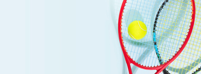 Tennis competition banner. Sport composition with yellow tennis ball and tennis rackets on a blue...