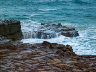 Fototapeta premium Top down seascape, water cascades and rock platform
