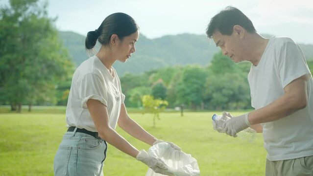 Asian family volunteers helping each other collecting littered rubbish cleaning up the park, sustainable environment awareness, teamwork spirit recycle reuse for green environment, less plastic waste