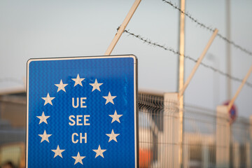 Details with an European Union flag and barbed wire at a Romanian border crossing.
